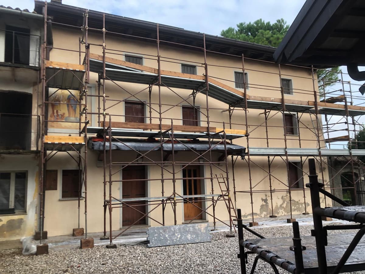 Cantiere ristrutturazione completa con ponteggi su edificio